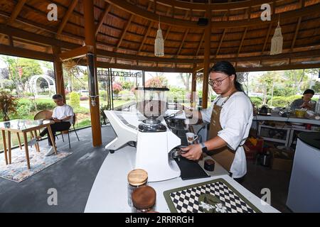 230612 -- HANGZHOU, 12. Juni 2023 -- Ein Barista arbeitet in einem Café im Dorf Wupu in Huzhou, Ostchinesische Provinz Zhejiang, 11. April 2023. Im Juni 2003 startete Zhejiang das Green Rural Revival Program, das etwa 10.000 eingegliederte Dörfer sanieren und etwa 1.000 zentrale Dörfer in Beispiele von mäßigem Wohlstand in jeder Hinsicht verwandeln will. Dank des Programms wurde das Bild der Landschaft in der Provinz Zhejiang umfassend aufgewertet. Insgesamt wurden 2.170 Dörfer und über 3 Millionen schöne ländliche Innenhöfe gebaut. CHINA-ZHEJIANG-GRE Stockfoto