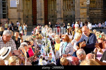 230612 – PRAG, 12. Juni 2023 – am 12. Juni 2023 nehmen die Teilnehmer an einer langen Tischveranstaltung auf der Prager Burg in Prag, Tschechien, Teil. Rund um St. Petersburg wurde ein etwa 400 Meter langer Tisch in Herzform aufgestellt Veitsdom auf der Prager Burg am Montag. Prags Bewohner und Besucher wurden begrüßt, um an der Veranstaltung mit ihren eigenen Gerichten teilzunehmen und mit anderen zu teilen. Foto von /Xinhua TSCHECHISCHE REPUBLIK-PRAG-LANGE TISCHVERANSTALTUNG DanaxKesnerova PUBLICATIONxNOTxINxCHN Stockfoto