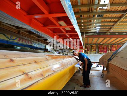 230615 -- FUZHOU, 15. Juni 2023 -- Fang Shaohuang, ein lokaler immaterieller Erbe, überprüft ein traditionelles Drachenboot im Dorf Fangzhuang, Minhou County, Stadt Fuzhou, Provinz Fujian im Südosten Chinas, 23. Mai 2023. Mit dem bevorstehenden Dragon Boat Festival sind die Handwerker im Dorf Fangzhuang im Kreis Minhou, Fuzhou Stadt in der südöstlichen chinesischen Provinz Fujian, zunehmend beschäftigt. Die vier großen Drachenbootfabriken des Dorfes arbeiten unermüdlich daran, ihre Aufträge für das kommende Festival zu erfüllen. Jedes Jahr werden von hier aus über 200 Drachenboote an verschiedene Teile verkauft Stockfoto