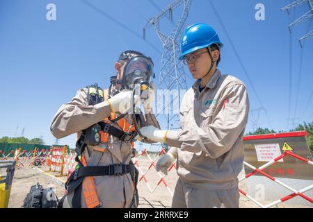 230616 -- TIANJIN, 16. Juni 2023 -- Ein Mitarbeiter L der State Grid Tianjin Electric Power Company trägt eine Überdruckmaske, bevor er unterirdische Tunnel in Tianjin, Nordchina, patrouilliert, 16. Juni 2023. UM MIT China Fokus ZU GEHEN: China wacht über die Sommerernte, Lebensordnung gegen sengende Hitzewellen CHINA-TIANJIN-HITZEWELLEN-STROMVERSORGUNG-PATROUILLE CN XinxHua PUBLICATIONxNOTxINxCHN Stockfoto