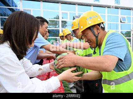 230616 -- TIANJIN, 16. Juni 2023 -- Mitarbeiter verteilen Wassermelonen an Konstrukteure auf einer Baustelle im Binhai New Area in Tianjin, Nordchina, 16. Juni 2023. UM MIT DER Hitzewelle ZU GEHEN, trifft Peking und hebt die Temperatur auf 39 Grad Celsius CHINA-HITZEWELLEN-ARBEITER-FÜRSORGLICHE CN ZhaoxZishuo PUBLICATIONxNOTxINxCHN Stockfoto