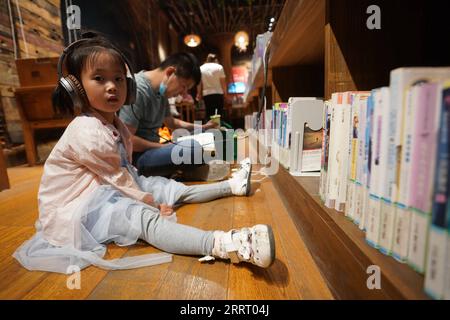 230619 -- YANGZHOU, 19. Juni 2023 -- Ein Kind hört Geschichten in einem Buchladen in Yangzhou, ostchinesische Provinz Jiangsu, 15. Juni 2023. Der chinesische Canal Grande, eine riesige Wasserstraße, die den nördlichen und südlichen Teil Chinas verbindet, wurde 2014 zum UNESCO-Weltkulturerbe erklärt. Yangzhou, eine malerische Stadt, durch die der Grand Canal verläuft, ist bekannt für Sehenswürdigkeiten am Kanal wie den schlanken West Lake und das malerische Gebiet des Sanwan-Kanals. In den letzten Jahren hat sich die Stadt dem Schutz ihres historischen und kulturellen Erbes, der Erhaltung der charakteristischen Merkmale der Altstadt und der Verbesserung der Péro verschrieben Stockfoto