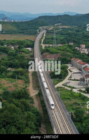 230620 -- SHENGZHOU, 20. Juni 2023 -- dieses Luftbild vom 19. Juni 2023 zeigt einen Hochgeschwindigkeitszug, der auf der Überlandbahn Hangzhou-Shaoxing-Taizhou in Shengzhou, der ostchinesischen Provinz Zhejiang, verkehrt. Die Überlandbahn Hangzhou-Shaoxing-Taizhou gehört zu Chinas erster Gruppe von Hochgeschwindigkeitsbahnprojekten, die von einer öffentlich-privaten Partnerschaft PPP finanziert werden, wobei der private Sektor einen Holding-Status hat. Seit dem offiziellen Betrieb der Bahn im Januar 2022 sind mehr als 10 Millionen Fahrgäste auf der Strecke. Die 266 km lange Eisenbahnstrecke mit einer geplanten Geschwindigkeit von 350 km/h, Stockfoto