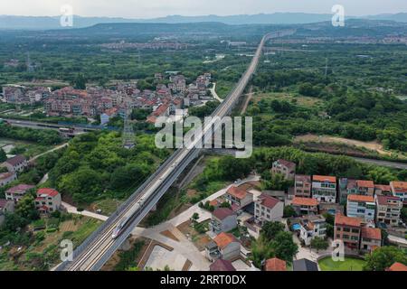 230620 -- SHENGZHOU, 20. Juni 2023 -- dieses Luftbild vom 19. Juni 2023 zeigt einen Hochgeschwindigkeitszug, der auf der Überlandbahn Hangzhou-Shaoxing-Taizhou in Shengzhou, der ostchinesischen Provinz Zhejiang, verkehrt. Die Überlandbahn Hangzhou-Shaoxing-Taizhou gehört zu Chinas erster Gruppe von Hochgeschwindigkeitsbahnprojekten, die von einer öffentlich-privaten Partnerschaft PPP finanziert werden, wobei der private Sektor einen Holding-Status hat. Seit dem offiziellen Betrieb der Bahn im Januar 2022 sind mehr als 10 Millionen Fahrgäste auf der Strecke. Die 266 km lange Eisenbahnstrecke mit einer geplanten Geschwindigkeit von 350 km/h, Stockfoto