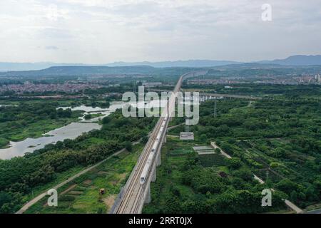 230620 -- SHENGZHOU, 20. Juni 2023 -- dieses Luftbild vom 19. Juni 2023 zeigt einen Hochgeschwindigkeitszug, der auf der Überlandbahn Hangzhou-Shaoxing-Taizhou in Shengzhou, der ostchinesischen Provinz Zhejiang, verkehrt. Die Überlandbahn Hangzhou-Shaoxing-Taizhou gehört zu Chinas erster Gruppe von Hochgeschwindigkeitsbahnprojekten, die von einer öffentlich-privaten Partnerschaft PPP finanziert werden, wobei der private Sektor einen Holding-Status hat. Seit dem offiziellen Betrieb der Bahn im Januar 2022 sind mehr als 10 Millionen Fahrgäste auf der Strecke. Die 266 km lange Eisenbahnstrecke mit einer geplanten Geschwindigkeit von 350 km/h, Stockfoto