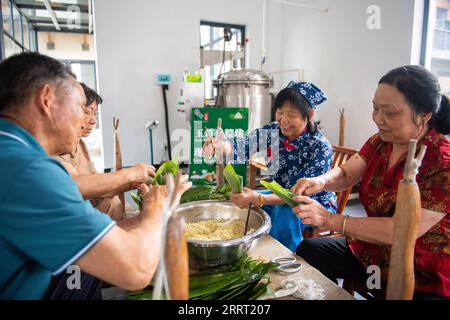 230623 -- CHANGSHA, 23. Juni 2023 -- die Leute machen Zongzi, einen pyramidenförmigen Knödel aus glutinösem Reis, der in Bambus oder Schilfblätter gewickelt ist, in der Stadt Quzici in der Stadt Miluo, Provinz Hunan in Zentralchina, 22. Juni 2023. MIT in ganz China: Verbinden Sie Tradition und Innovation beim Dragon Boat Festival CHINA-HUNAN-MILUO-DRAGON BOAT FESTIVAL CN ChenxSihan PUBLICATIONxNOTxINxCHN Stockfoto