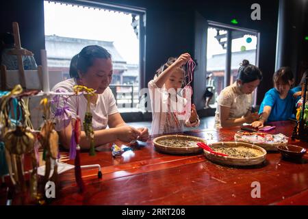 230623 -- CHANGSHA, 23. Juni 2023 -- Touristen machen chinesische traditionelle Beutel in einem Kulturpark in der Stadt Quzici in der Stadt Miluo, Provinz Hunan in Zentralchina, 22. Juni 2023. MIT in ganz China: Verbinden Sie Tradition und Innovation beim Dragon Boat Festival CHINA-HUNAN-MILUO-DRAGON BOAT FESTIVAL CN ChenxSihan PUBLICATIONxNOTxINxCHN Stockfoto