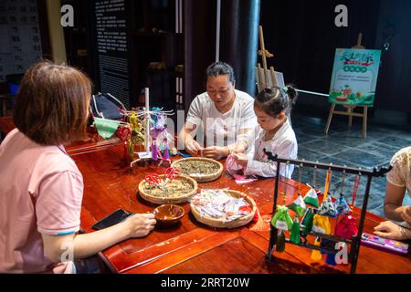 230623 -- CHANGSHA, 23. Juni 2023 -- Touristen machen chinesische traditionelle Beutel in einem Kulturpark in der Stadt Quzici in der Stadt Miluo, Provinz Hunan in Zentralchina, 22. Juni 2023. MIT in ganz China: Verbinden Sie Tradition und Innovation beim Dragon Boat Festival CHINA-HUNAN-MILUO-DRAGON BOAT FESTIVAL CN ChenxSihan PUBLICATIONxNOTxINxCHN Stockfoto