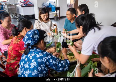 230623 -- CHANGSHA, 23. Juni 2023 -- die Leute machen Zongzi, einen pyramidenförmigen Knödel aus glutinösem Reis, der in Bambus oder Schilfblätter gewickelt ist, in der Stadt Quzici in der Stadt Miluo, Provinz Hunan in Zentralchina, 22. Juni 2023. MIT in ganz China: Verbinden Sie Tradition und Innovation beim Dragon Boat Festival CHINA-HUNAN-MILUO-DRAGON BOAT FESTIVAL CN ChenxSihan PUBLICATIONxNOTxINxCHN Stockfoto