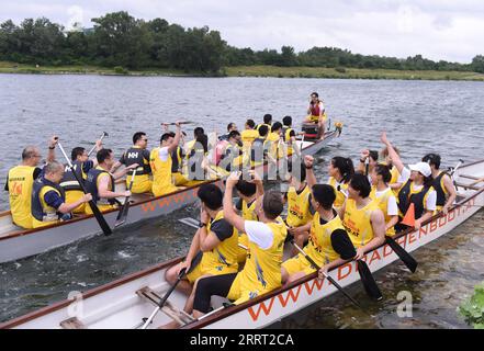 230625 -- WIEN, 25. Juni 2023 -- Mitglieder von zwei Drachenbootteams grüßen sich vor dem Wiener Donau-Drachenboot-Cup 2023 in Wien, Österreich, Juni. 24, 2023. SPAUSTRIA-VIENNA-DANUBE DRAGON BOAT CUP HEXCANLING PUBLICATIONXNOTXINXCHN Stockfoto