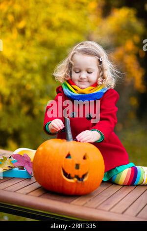 Kind schnitzt Halloween Kürbis. Kinder schnitzen Kürbisse für Trick or Treat Jack o Laterne. Herbstaktivitäten für Kinder. Stockfoto