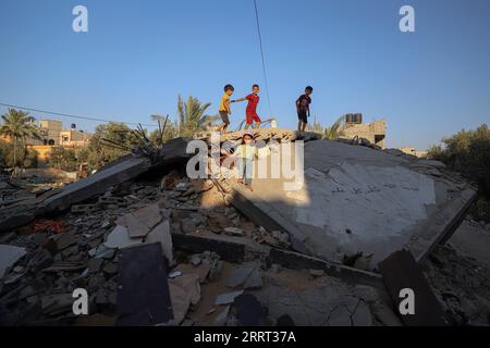 230627 -- GAZA, 27. Juni 2023 -- palästinensische Kinder stehen auf den Ruinen der Häuser im Flüchtlingslager Deir al-Balah im zentralen Gazastreifen, 20. Juni 2023. Da ihr Haus bei den jüngsten israelischen Luftangriffen zerstört wurde, wird vielen Gazern die Freude über das diesjährige Eid al-Adha beraubt, eines der am meisten gefeierten Feste im islamischen Kalender. ZU GEHEN MIT Feature: Gazaner beraubt der Eid Freude mit Haus zerstört in Luftangriffen Foto von /Xinhua MIDEAST-GAZA STADT-EID AL-ADHA-DISPLACED PEOPLE RizekxAbdeljawad PUBLICATIONxNOTxINxCHN Stockfoto