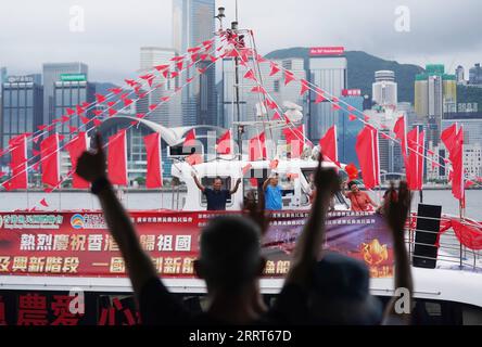 230701 -- HONG KONG, 1. Juli 2023 -- Bürger sehen ein Fischereifahrzeug mit Flaggen, das am Victoria Harbour in Hong Kong, Südchina, am 1. Juli 2023 kreuzt. Das Hongkonger Fischer-Konsortium hat die Kreuzfahrt gestartet, um den 26. Jahrestag der Rückkehr Hongkongs ins Mutterland zu feiern. CHINA-HONG KONG-RÜCKKEHR ZUR MUTTERLAND-FEIER CN WANGXSHEN PUBLICATIONXNOTXINXCHN Stockfoto