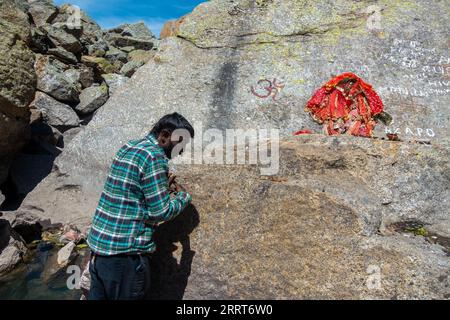 30. August 2023, Himachal Pradesh, Indien. Ein Mann in der Anbetung in Parvati Kund, einem heiligen Ort auf der Kinner Kailash Yatra Pilgerfahrt. Stockfoto