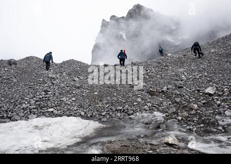 230707 -- LIJIANG, 7. Juli 2023 -- Wang Shijin 1. L begibt sich mit Teamkollegen auf den Yulong Snow Mountain in der Stadt Lijiang, Provinz Yunnan im Südwesten Chinas, am 19. Juni 2023 zum Baishui River No. 1 Glacier. Die Forschungsstation Yulong Snow Mountain Cryosphere and Sustainable Development Field Science Observation and Research Station, die vom Northwest Institute of Eco-Environment and Resources of Chinese Academy of Sciences eingerichtet wurde, befindet sich in Lijiang City in der Provinz Yunnan im Südwesten Chinas. Seit 2006 überwachen Forscher regelmäßig den Zustand des Baishui River No. 1 Glacier und seiner Umgebung Stockfoto