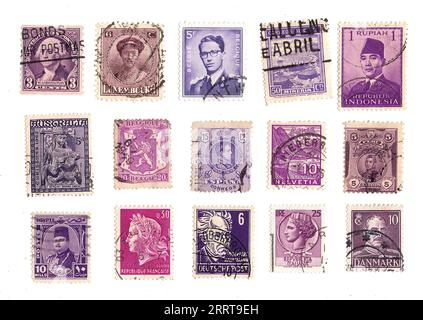 Lila Briefmarken aus aller Welt auf weißem Hintergrund. Stockfoto
