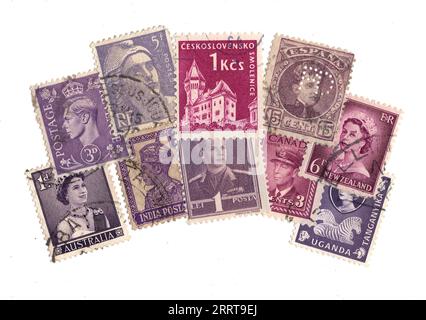Lila Briefmarken aus aller Welt auf weißem Hintergrund. Stockfoto