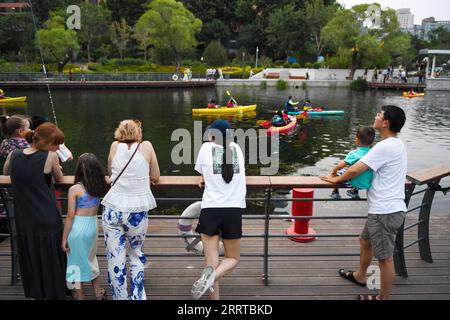 230713 -- PEKING, 13. Juli 2023 -- Touristen genießen den Blick auf den Fluss Liangma in Peking, Hauptstadt von China, 23. Juni 2023. Die seine, der zweitgrößte Fluss Frankreichs, schlängelt sich durch das Herz von Paris. Sie fließt von West nach Ost und teilt die Stadt in das ikonische linke und rechte Ufer. Das linke Ufer ist geprägt von einem künstlerischen Ambiente, das mit Cafés, Theatern und Buchläden geschmückt ist und einen Hafen für den literarischen Kreis und ein Kulturparadies schafft. Auf der anderen Seite beherbergt das rechte Ufer prestigeträchtige Sehenswürdigkeiten wie den Louvre, den ehemaligen königlichen Palast und den Elysee-Palast, das c Stockfoto