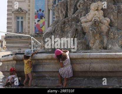 230720 -- MONTPELLIER, 20. Juli 2023 -- Kinder kühlen sich an einem Brunnen von drei Grazen auf dem Place de Comedie ab, da die höchste Temperatur in Montpellier, Südfrankreich, am 19. Juli 2023 38 Grad Celsius erreicht. Am Mittwoch wurden in ganz Europa Warnungen wegen extremer Hitze ausgegeben, da der beste Teil des Kontinents von der intensivsten Hitzewelle seit Beginn der Aufzeichnungen erfasst wurde. FRANCE-MONTPELLIER-HEATWAVE GaoxJing PUBLICATIONxNOTxINxCHN Stockfoto