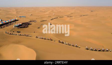 230721 -- ZHONGWEI, 21. Juli 2023 -- dieses Luftbild, das am 20. Juli 2023 aufgenommen wurde, zeigt Besucher, die auf Kamelen am malerischen Ort Shapotou in Zhongwei, der nordwestlichen chinesischen Autonomen Region Ningxia Hui, reiten. Shapotou landschaftlich reizvolle Stelle in Zhongwei im Nordwesten Chinas Ningxia hat seine höchste touristische Saison während der Sommerferien begonnen, mit dem größten täglichen Besucherstrom von über 10.000. CHINA-NINGXIA-ZHONGWEI-SHAPOTOU LANDSCHAFTLICH REIZVOLLER SPOT-TOURISMUS CN WANGXYUGUO PUBLICATIONXNOTXINXCHN Stockfoto