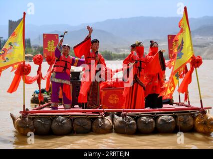 230721 -- ZHONGWEI, 21. Juli 2023 -- Schauspieler führen Hochzeitszeremonie auf Lammfellflößen am Shapotou Scenic Spot in Zhongwei, Nordwestchina Ningxia Hui Autonomous Region, 20. Juli 2023 durch. Shapotou landschaftlich reizvolle Stelle in Zhongwei im Nordwesten Chinas Ningxia hat seine höchste touristische Saison während der Sommerferien begonnen, mit dem größten täglichen Besucherstrom von über 10.000. CHINA-NINGXIA-ZHONGWEI-SHAPOTOU LANDSCHAFTLICH REIZVOLLER SPOT-TOURISMUS CN FENGXKAIHUA PUBLICATIONXNOTXINXCHN Stockfoto