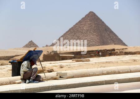 230722 -- KAIRO, 22. Juli 2023 -- Ein Mann ruht in einem Schatten vom Deckel eines Mülleimers an der malerischen Stelle der Pyramiden von Gizeh während einer Hitzewelle, in Gizeh, Ägypten, 22. Juli 2023. ÄGYPTEN-WETTER-HITZEWELLE SuixXiankai PUBLICATIONxNOTxINxCHN Stockfoto