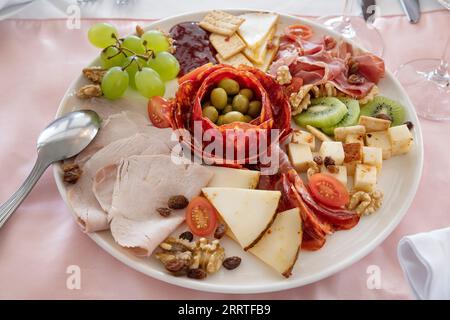 Platte mit einer vielfältigen Auswahl an spanischem Aufschnitt und Käse wie Chorizos, Serrano und geräucherten Schinken sowie Manchego- und Ziegenkäse Stockfoto