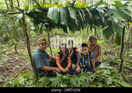 230726 -- JINPING, 26. Juli 2023 -- Zhang Puzhong 1st L, seine Frau Wang Suying 1st R und ihre Enkelkinder posieren für ein Foto unter einem Bananenblattschuppen im Wald in der Nähe von Xiaxinzhai Village, Zhemi Township, Jinping County, Honghe Hani und Yi Autonomous Prefecture, Südwestchinesische Provinz Yunnan, 23. Juli 2023. Nach Tagen des Denkens beschloss Zhang Puzhong, seinen Enkelkindern etwas lehrreiches zu tun: Sie zurück in den Wald zu bringen, in dem er vor mehr als 60 Jahren als Kind lebte. Das ist sehr wichtig. Ich weiß, wie glücklich ich heute bin, weil ich nie vergessen habe, wie bitter mein Leben in der Vergangenheit war, Stockfoto