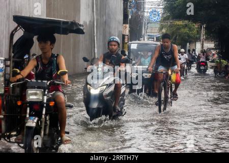 230726 -- MALABON CITY, 26. Juli 2023 -- Menschen waten am 26. Juli 2023 durch ein wasserverschmutztes Gebiet in Malabon City auf den Philippinen. Die philippinische Katastrophenbehörde sagte am Mittwoch, dass sie bisher mindestens einen Toten gezählt habe, da der Taifun Doksuri das Land weiterhin mit Regen und starken Winden prügelte. Doksuri hat acht Regionen auf der Insel Luzon und den zentralen Philippinen betroffen. Fast 9.000 Vertriebene bleiben in 107 Evakuierungszentren, fügte der National Disaster Risk Reduction and Management Council hinzu. DIE PHILIPPINEN-MALABON-STADT-TAIFUN DOKSURI ROUELLEXUMALI PUBLIC Stockfoto