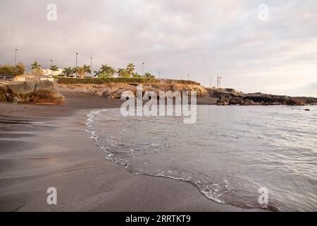 Bewölkter Nachmittag über einem abgeschiedenen Strand mit schwarzem vulkanischem Sand, bekannt als Playa la Jaquita, in der Nähe der kleinen Stadt Alcala in Guia de Isora Stockfoto