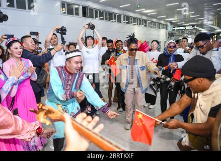 230730 -- ÜRÜMQI, 30. Juli 2023 -- Mitglieder der Muqam Art Troupe des Xinjiang Art Theater Dance begrüßen eine südafrikanische Tanzgruppe auf dem Urumqi Diwopu International Airport in Ürümqi, Nordwestchina Xinjiang Uygur Autonomous Region, 24. Juli 2023. Das 6. China Xinjiang International Dance Festival hat mehr als 1.000 Künstler aus Ländern und Regionen in Asien, Europa und Afrika angezogen und wird voraussichtlich etwa 60 bekannte Aufführungen präsentieren. CHINA-XINJIANG-ÜRÜMQI-TANZ-FESTIVAL-KULTURAUSTAUSCH CN HUXHUHU PUBLICATIONXNOTXINXCHN Stockfoto