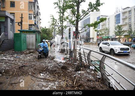 230801 -- PEKING, 1. Aug. 2023 -- Fußgänger gehen auf einer matschigen Straße im überfluteten Mentougou Bezirk von Peking, Hauptstadt von China, 31. Juli 2023. Xinhua Schlagzeilen: China geht alles daran, gegen Taifun-induzierte sintflutartige Regenfälle, Überschwemmungen JuxHuanzong PUBLICATIONxNOTxINxCHN vorzugehen Stockfoto