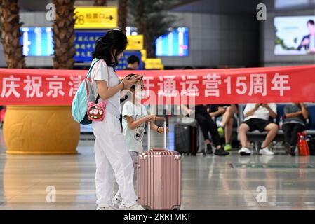 230801 -- TIANJIN, 1. Aug. 2023 -- Passagiere warten auf einen Zug, der auf der Intercity-Bahn Peking-Tianjin am Tianjin Bahnhof im nordchinesischen Tianjin verkehrt, 1. Aug. 2023. Die Intercity-Bahn Peking-Tianjin feierte ihren 15. Jahrestag der Eröffnung am Dienstag. Als erste Hochgeschwindigkeitsbahn HSR mit einer planmäßigen Geschwindigkeit von 350 km/h in China beförderte die Intercity-Bahn Peking-Tianjin seit ihrer Inbetriebnahme insgesamt 340 Millionen Passagiere. Bis 2022 hatte China 42.000 km an betriebsfähigem HSR, der weltweit erste Platz, und die Länge der Hochgeschwindigkeitsbahn war regelmäßig in Betrieb Stockfoto