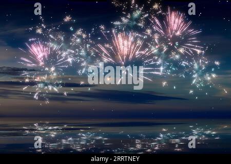 Wunderschönes Frohes Neujahrsfeuerwerk Im Himmel Mit Reflexionen Auf Dem Wasser. Stockfoto