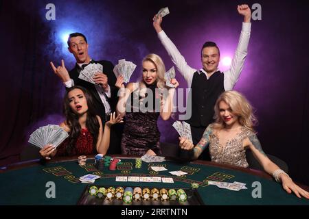 Eine Gruppe junger wohlhabender Freunde spielt Poker in einem Casino. Stockfoto