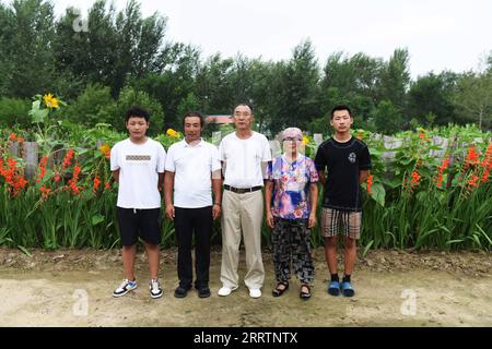 230803 -- TONGLIAO, 3. Aug. 2023 -- Bai Shun C posiert für Fotos mit seiner Familie in Bulteger Gacha, Horqin Linker Flügel Hinteres Banner der Stadt Tongliao, Nordchina Innere Mongolei Autonome Region, 2. Aug. 2023. Bulteger Gacha, ein kleines Dorf in Horqin im linken Flügel hinter dem Banner der Stadt Tongliao, befand sich im Zentrum des Horqin Sandy Landes und litt früher unter Wüstenbildung. Seit 2002 hat Bai Shun, ein ortsansässiger mongolischer Bauer, seine Familie dazu gebracht, sich in diesem Dorf zu verwurzeln und sich der Kontrolle der Wüstenbildung zu widmen. Die Überlebensrate der gepflanzten Bäume war zu Beginn aufgrund fehlender Bäume niedrig Stockfoto