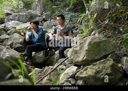 230814 -- LU AN, 14. August 2023 -- Wang Kedong und seine Frau Gao Kaiyu machen eine Pause während der Patrouille auf der Tiantangzhai Management Station im Anhui Tianma National Nature Reserve, ostchinesische Provinz Anhui, 11. August 2023. Wang Kedong und Gao Kaiyu, beide 58 Jahre alt, sind Ranger der Tiantangzhai Management Station des Anhui Tianma National Nature Reserve. Sie leben das ganze Jahr über in den Bergen und patrouillieren seit 25 Jahren täglich auf einer Strecke von mehr als 20 Kilometern. Das Anhui Tianma National Nature Reserve wurde 1998 auf der Grundlage von zwei ehemaligen Anhui Provincial Nature Reserves gegründet. I Stockfoto