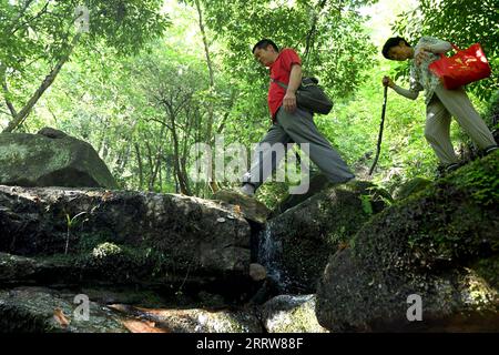 230814 -- LU AN, 14. August 2023 -- Wang Kedong und seine Frau Gao Kaiyu patrouillieren auf der Tiantangzhai Management Station im Anhui Tianma National Nature Reserve, ostchinesische Provinz Anhui, 12. August 2023. Wang Kedong und Gao Kaiyu, beide 58 Jahre alt, sind Ranger der Tiantangzhai Management Station des Anhui Tianma National Nature Reserve. Sie leben das ganze Jahr über in den Bergen und patrouillieren seit 25 Jahren täglich auf einer Strecke von mehr als 20 Kilometern. Das Anhui Tianma National Nature Reserve wurde 1998 auf der Grundlage von zwei ehemaligen Anhui Provincial Nature Reserves gegründet. Sie befindet sich an der tr Stockfoto