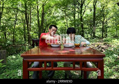 230814 -- LU AN, 14. August 2023 -- Wang Kedong und seine Frau Gao Kaiyu essen an einem Stand der Tiantangzhai Management Station im Anhui Tianma National Nature Reserve, ostchinesische Provinz Anhui, 12. August 2023. Sie leben in dieser Station während der kritischen Phase der Brandverhütung vom 1. Oktober bis zum 30. April. Wang Kedong und Gao Kaiyu, beide 58 Jahre alt, sind Ranger der Tiantangzhai Management Station des Anhui Tianma National Nature Reserve. Sie leben das ganze Jahr über in den Bergen und patrouillieren seit 25 Jahren täglich auf einer Strecke von mehr als 20 Kilometern. Anhui Tianma National Natur Stockfoto