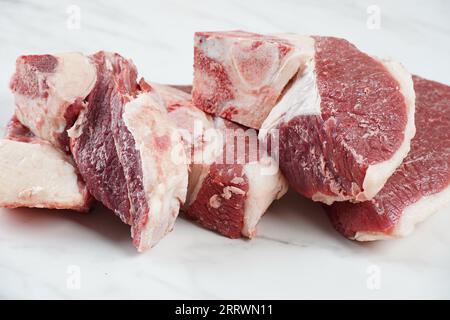 Frische rohe Rindersteaks mit Knochen auf dem Schneidebrett, bereit zum Kochen von Asado Stockfoto