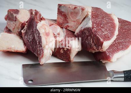 Frische rohe Rindersteaks mit Knochen auf dem Schneidebrett, bereit zum Kochen von Asado Stockfoto