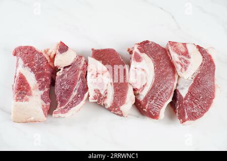 Frische rohe Rindersteaks mit Knochen auf dem Schneidebrett, bereit zum Kochen von Asado Stockfoto