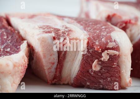 Frische rohe Rindersteaks mit Knochen auf dem Schneidebrett, bereit zum Kochen von Asado Stockfoto