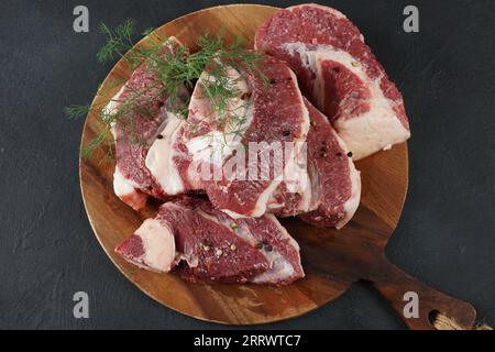 Frische rohe Rindersteaks mit Knochen auf dem Schneidebrett, bereit zum Kochen von Asado Stockfoto