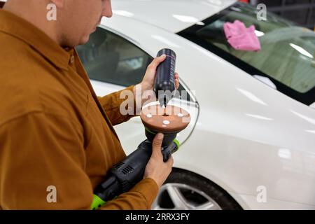 Man Autobesitzer, der Wachs oder poliercreme auf die Schleifscheibe aufträgt Stockfoto