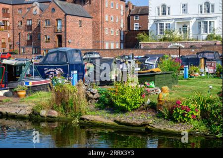 Schmalboote legten vor den alten und neuen Häusern an, die das Kanalbecken in Stourport upon Severn in Worcestershire umgeben. Stockfoto