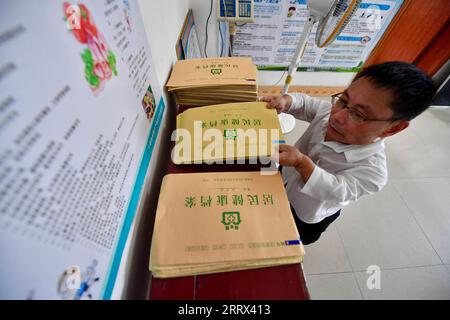 230819 -- NANCHANG, 19. August 2023 -- Xiao Jiulin arrangiert die Gesundheitsakten der Dorfbewohner in seiner Klinik im Dorf Yangang im Yudu County, ostchinesische Provinz Jiangxi, 16. August 2023. ZUM MITNEHMEN: Körperbehinderter Arzt bietet Grundversorgung für Hunderte CHINA-JIANGXI-KÖRPERBEHINDERTER ARZT CN HuxChenhuan PUBLICATIONxNOTxINxCHN Stockfoto