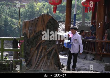 230819 -- QIANDONGNAN, 19. August 2023 -- Wu Changxi trinkt Wasser an einem Brunnen auf dem Weg zu Hausbesuchen im Dorf Dingnong im Kreis Rongjiang, Qiandongnan Miao und der autonomen Präfektur Dong, Provinz Guizhou im Südwesten Chinas, 16. August 2023. Wu Changxi, sein Sohn Wu Tao und seine Schwiegertochter Xiang Changhui sind allesamt Landärzte, die in drei Dörfern arbeiten und sich um die Gesundheit von mehr als 820 Haushalten und 3.660 Menschen kümmern. Foto von /Xinhua CHINA-GUIZHOU-RURAL DOCTORS-FAMILY CN WangxBingzhen PUBLICATIONxNOTxINxCHN Stockfoto