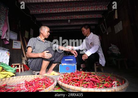 230819 -- QIANDONGNAN, 19. August 2023 -- Wu Changxi misst den Blutdruck eines Dorfbewohners während eines Hausbesuchs im Dorf Dingnong im Kreis Rongjiang, Qiandongnan Miao und der autonomen Präfektur Dong, Provinz Guizhou im Südwesten Chinas, 16. August 2023. Wu Changxi, sein Sohn Wu Tao und seine Schwiegertochter Xiang Changhui sind allesamt Landärzte, die in drei Dörfern arbeiten und sich um die Gesundheit von mehr als 820 Haushalten und 3.660 Menschen kümmern. Foto von /Xinhua CHINA-GUIZHOU-RURAL DOCTORS-FAMILY CN WangxBingzhen PUBLICATIONxNOTxINxCHN Stockfoto