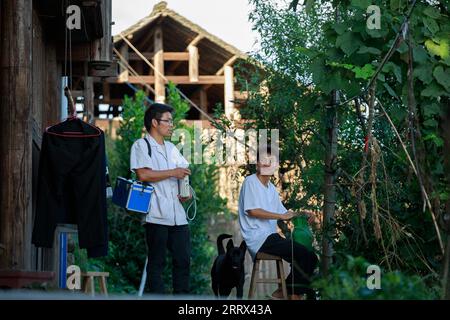 230819 -- QIANDONGNAN, 19. August 2023 -- Wu Tao spricht mit einem Dorfbewohner im Dorf Zendiu im Kreis Rongjiang, Qiandongnan Miao und der autonomen Präfektur Dong, Provinz Guizhou im Südwesten Chinas, 16. August 2023. Wu Changxi, sein Sohn Wu Tao und seine Schwiegertochter Xiang Changhui sind allesamt Landärzte, die in drei Dörfern arbeiten und sich um die Gesundheit von mehr als 820 Haushalten und 3.660 Menschen kümmern. CHINA-GUIZHOU-RURAL DOCTORS-FAMILY CN LIUXXU PUBLICATIONXNOTXINXCHN Stockfoto